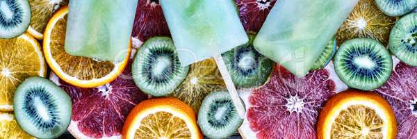 Concept: summer, heat, quenching thirst. Fruit ice, sliced fruit, kiwi, orange, grapefruit.
