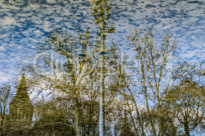 Reflection of castle and trees in water of lake.