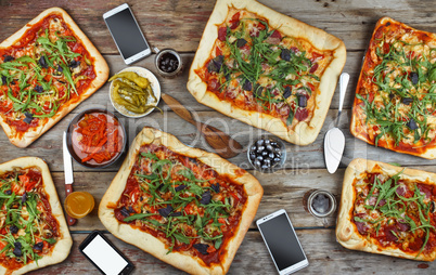 Appetizing homemade pizza on a wooden table. Friendly feast at home.