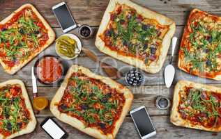 Appetizing homemade pizza on a wooden table. Friendly feast at home.