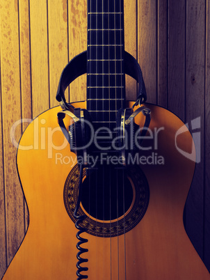 Old acoustic guitar with headphones