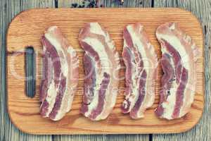 Raw steaks on a cutting board. Bacon.