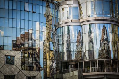 Reflection of houses in glass window of modern building.