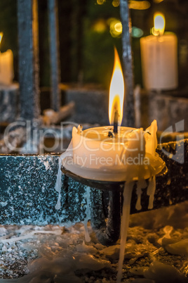 Candles glow in a dark in church.