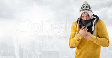 Man keeping warm in hat and scarf in bright city