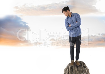 Businessman standing on rock looking down below