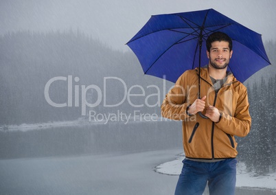 Man with umbrella over icy lake
