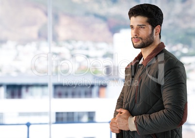 Man in coat by window of city