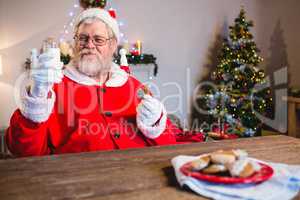 Santa Claus having a cookie with glass of milk