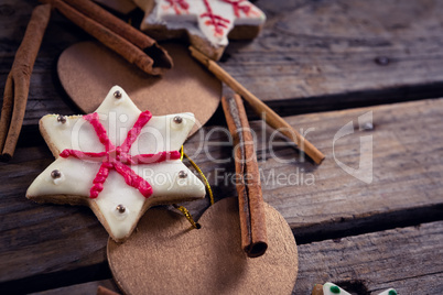 Cinnamon sticks, cookies and christmas decoration on wooden plank