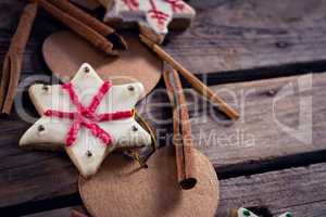 Cinnamon sticks, cookies and christmas decoration on wooden plank