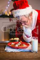 Santa Claus selecting cookies from plate