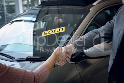 Cropped image of salesman doing handshake with customer