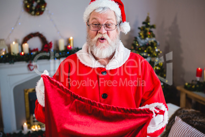 Santa claus holding gift sack at home