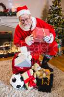 Portrait of santa claus holding gift box in living room