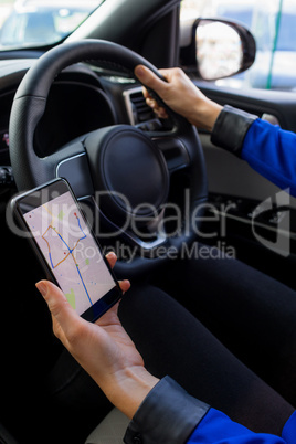 Close up of female customer using phone during test drive