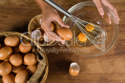 Man breaking eggs in bowl