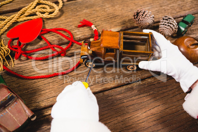 Santa repairing toy car during christmas time