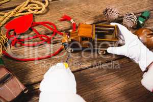 Santa repairing toy car during christmas time