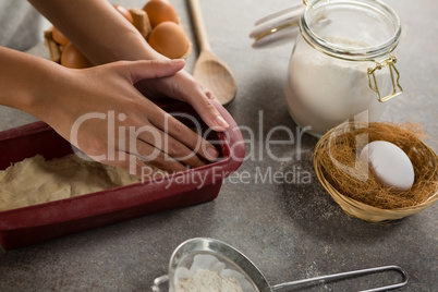 Woman preparing dough surrounded with various ingredients