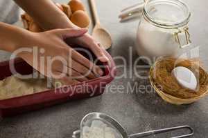 Woman preparing dough surrounded with various ingredients