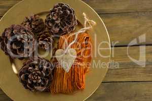 Overhead view of pine cones with thread in plate