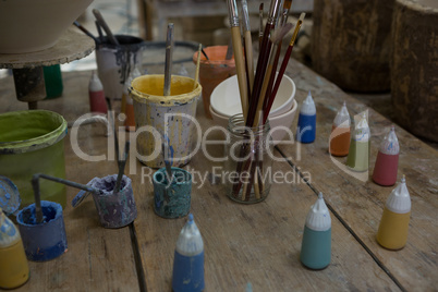 Watercolor cans and paintbrush in pottery workshop