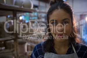 Female potter smiling in pottery workshop