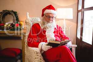 Santa claus reading novel in living room