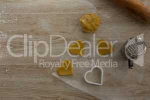Raw cookie dough with heart shaped cookie cutter and flour shaker strainer