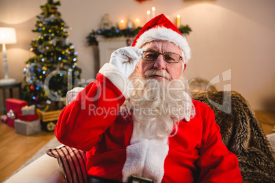 Portrait of santa claus sitting on sofa in living room at home