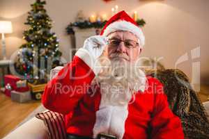 Portrait of santa claus sitting on sofa in living room at home