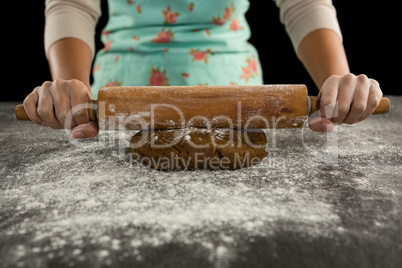Woman baking dough with rolling pin