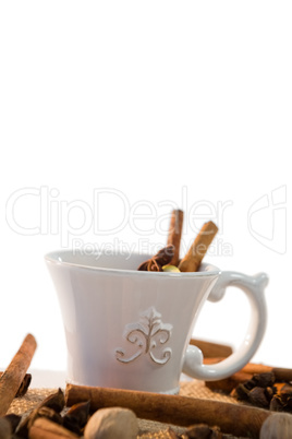 Spice tea with various ingredients against white background