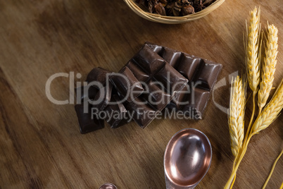 Chocolates and wheat ear on wooden table