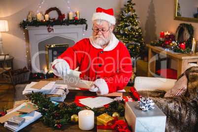 Santa Claus reading scroll in living room