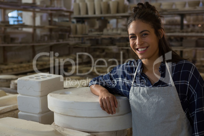 Female potter smiling in pottery workshop