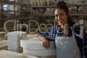 Female potter smiling in pottery workshop