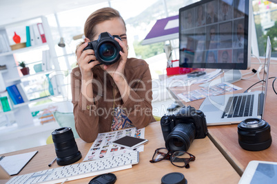 Female executive taking a photograph from digital camera