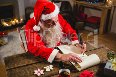 Santa Claus writing on scroll in living room