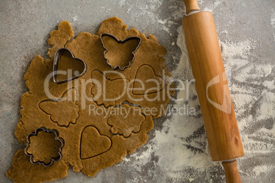 Gingerbread dough with flour, cookie cutter and rolling pin