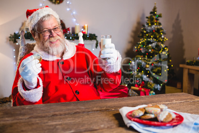 Santa Claus having a cookie with glass of milk