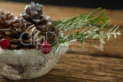 Close up of pine cones and twigs with cherry in bowl