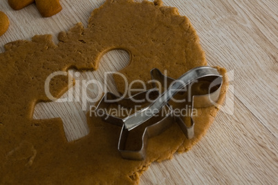 Gingerbread dough with cookie cutter on wooden table