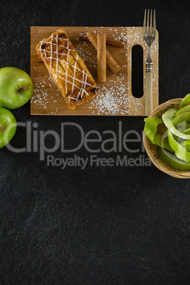 Tart and cinnamon sticks on chopping board