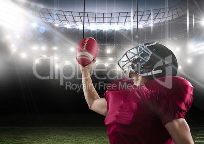 american football  player standing in stadium holding the ball