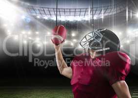 american football  player standing in stadium holding the ball