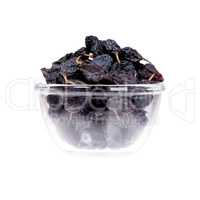 Saucer of prunes on white background, close up.
