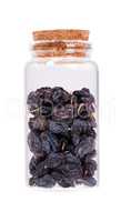 Black Raisins in a glass bottle with cork stopper, isolated on w