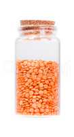 Lentils in a glass bottle with cork stopper, isolated on white.